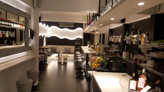 חלל מודרני בשחור ולבן עם דלפק ארוך, שרפרפים ותצוגת פירות