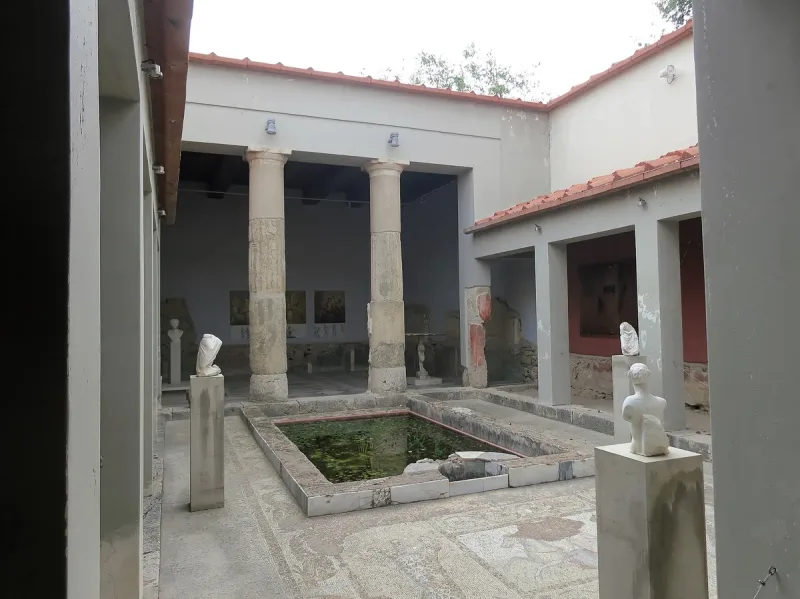 חצר פנימית עם עמודים, בריכת מים ופסלים בקאסה רומאנה, בית רומי משוחזר בעיר קוס