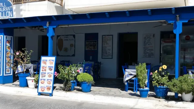 חזית כחולה לבנה עם לוחות תפריט מצולמים, כיסאות כחולים ועציצים על המדרכה