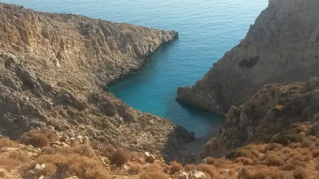 מפרצון צר ועמוק בין מצוקי סלע גבוהים, עם מים בגוון טורקיז