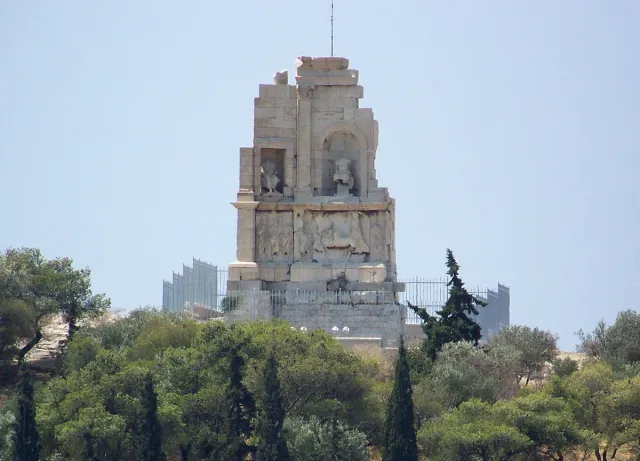 אנדרטת אבן עתיקה בפסגת גבעה מיוערת באורנים