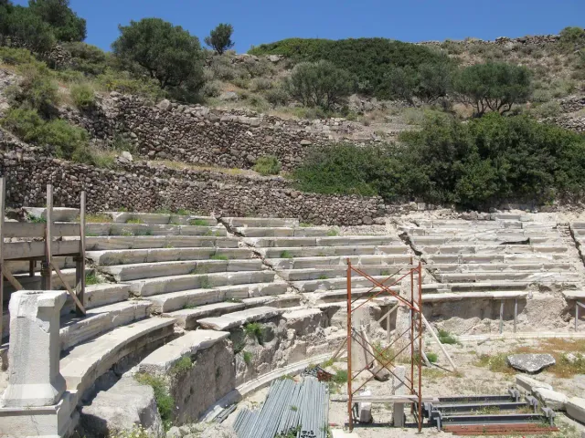שורות מושבי שיש לבן של תיאטרון עתיק במדרון