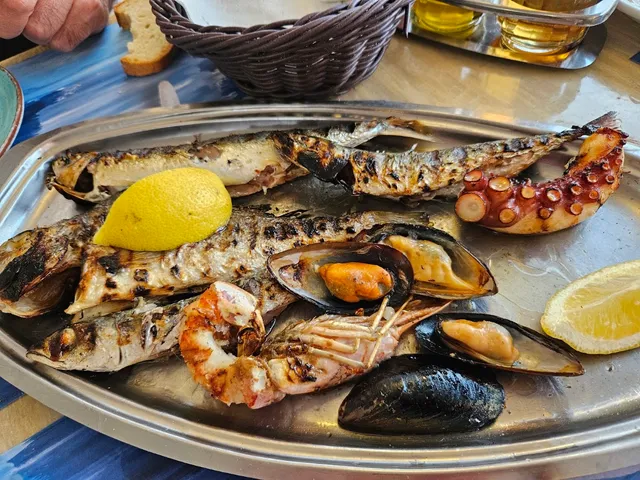 מגש של דגים צלויים, מולים, שרימפס ותמנון עם פלחי לימון