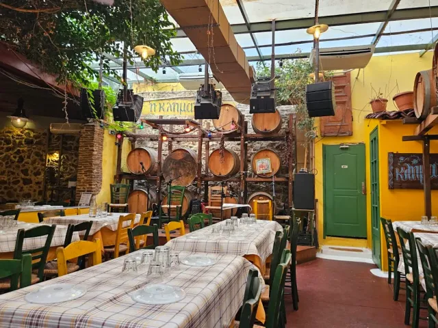 חצר מקורה עם חביות יין על מתקן, קירות צהובים ודלת ירוקה