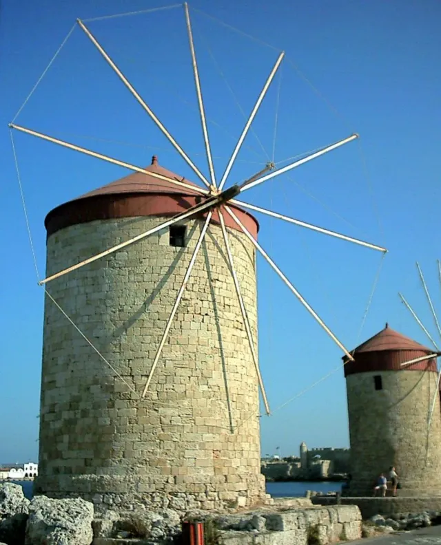 טחנות רוח אבן עגולות עם כנפי עץ, בשורה על המזח