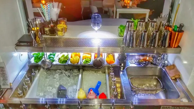 עמדת בר מנירוסטה עם קרח, פירות חתוכים ושייקרים מסודרים בשורה