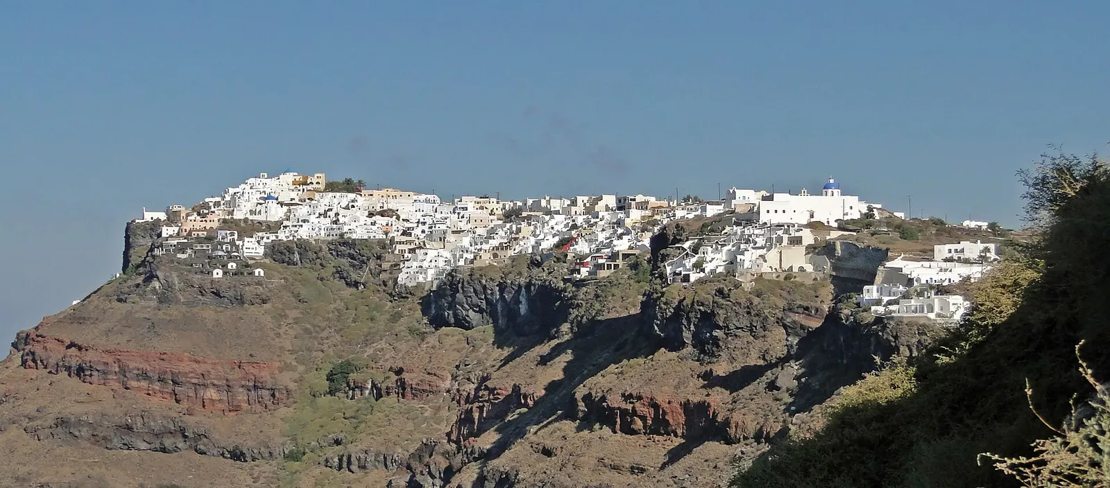 הכפר אימרוביגלי בסנטוריני ביוון עם בתים לבנים על שפת מצוק הקלדרה הוולקני